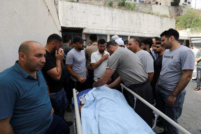 Palestinians gather around the body of a man who was killed during a confrontation with Israeli settlers, at a hospital in the Israeli-occupied West Bank city of Nablus
