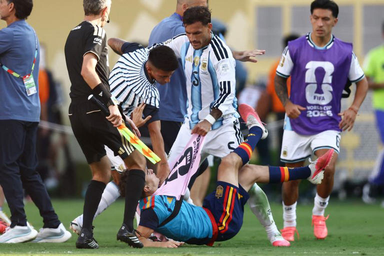 Argentina's midfielder Leandro Paredes (top) clashes with Spain's midfielder Gavi