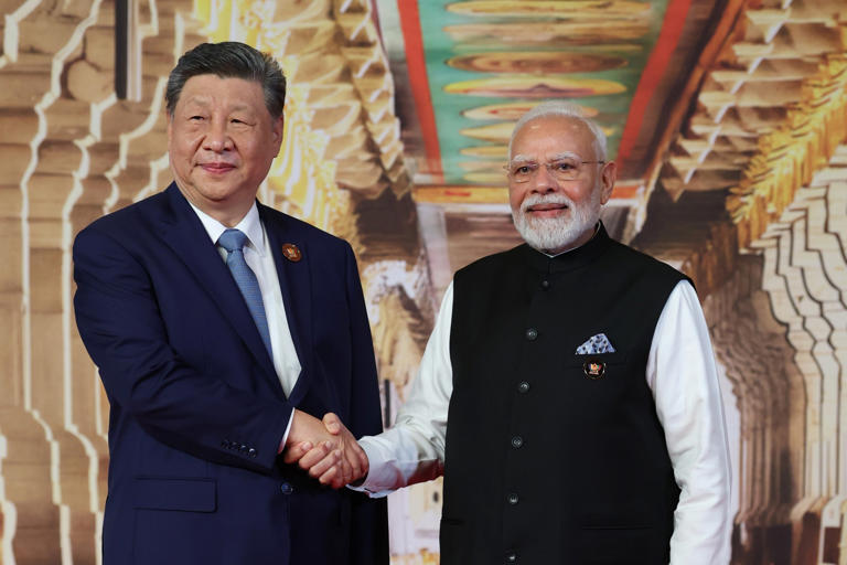 In this photo provided by the Indian Foreign Ministry, Indian Prime Minister Narendra Modi, right, greets Chinese President Xi Jinping upon his arrival for the BRICS summit in New Delhi, India
