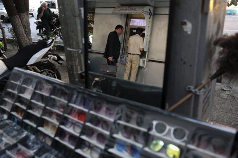 People use an ATM in front of a bank in Tehran, Iran, September 27, 2026.