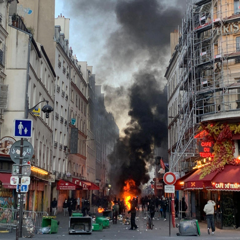 Flames engulf a street leading to Republic Square in Paris on Sunday